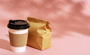 breakfast to go in paper packaging on pink background